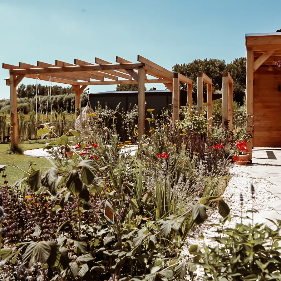 Modern landelijke tuin met Douglas overkapping en ruim gazon