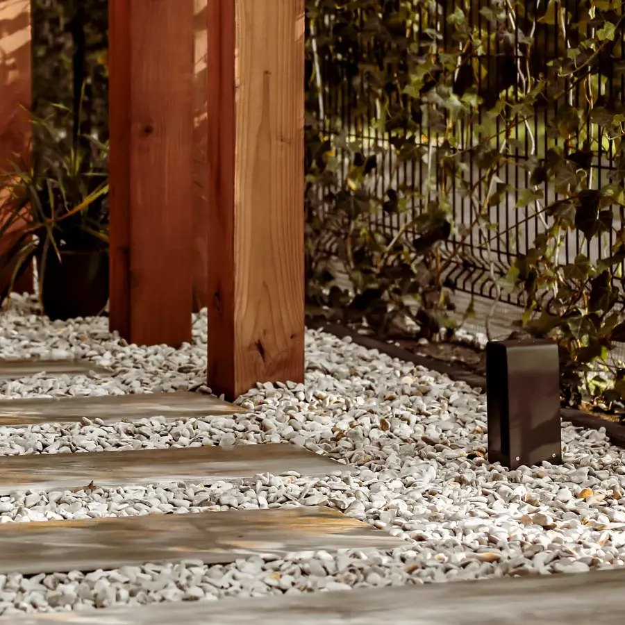 Strakke tuin met sfeervolle houten poortconstructie en buitenkeuken