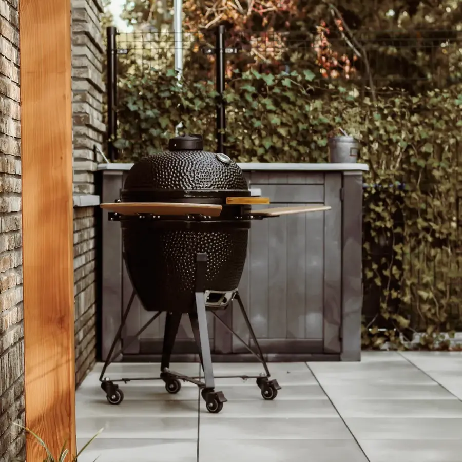 Strakke tuin met sfeervolle houten poortconstructie en buitenkeuken
