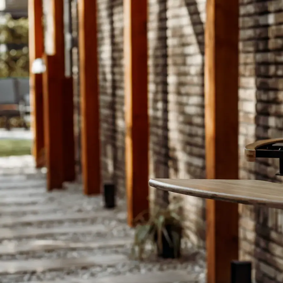 Strakke tuin met sfeervolle houten poortconstructie en buitenkeuken