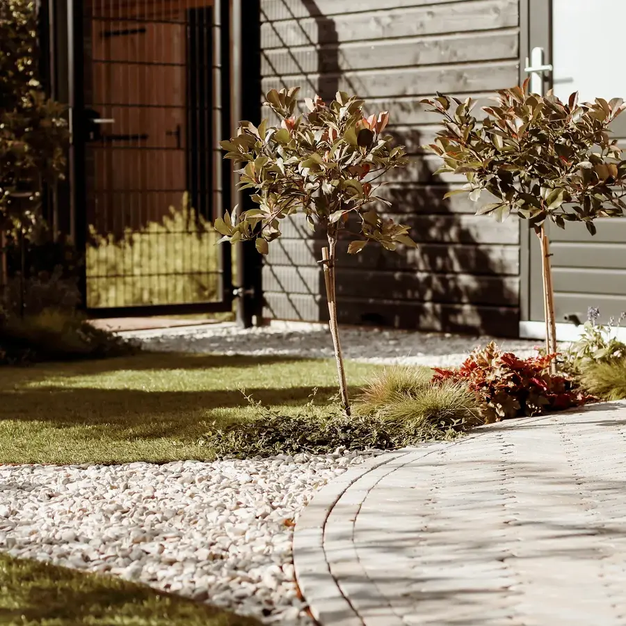 Strakke tuin met sfeervolle houten poortconstructie en buitenkeuken
