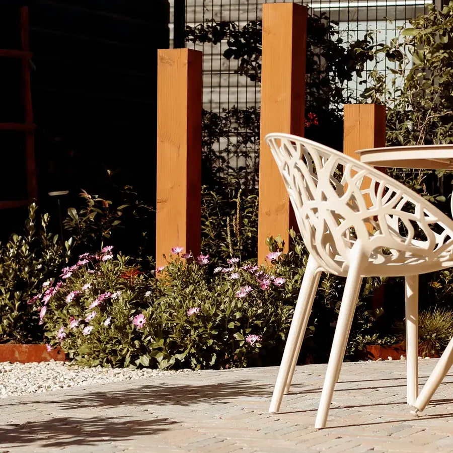 Strakke tuin met sfeervolle houten poortconstructie en buitenkeuken