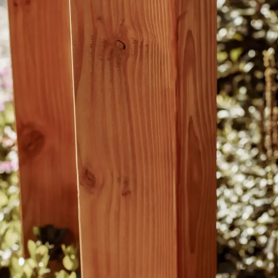 Strakke tuin met sfeervolle houten poortconstructie en buitenkeuken