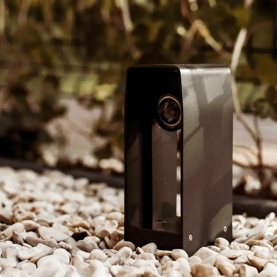 Strakke tuin met sfeervolle houten poortconstructie en buitenkeuken