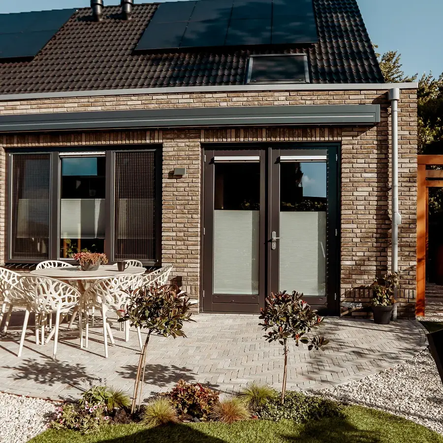 Strakke tuin met sfeervolle houten poortconstructie en buitenkeuken
