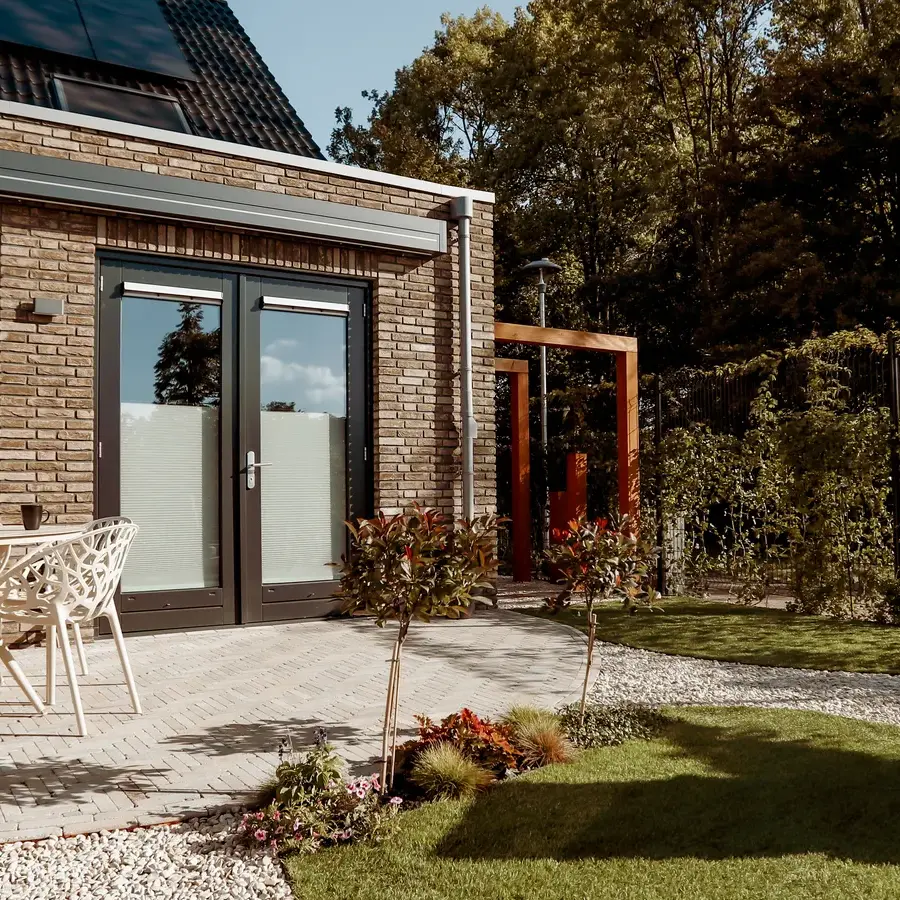 Strakke tuin met sfeervolle houten poortconstructie en buitenkeuken