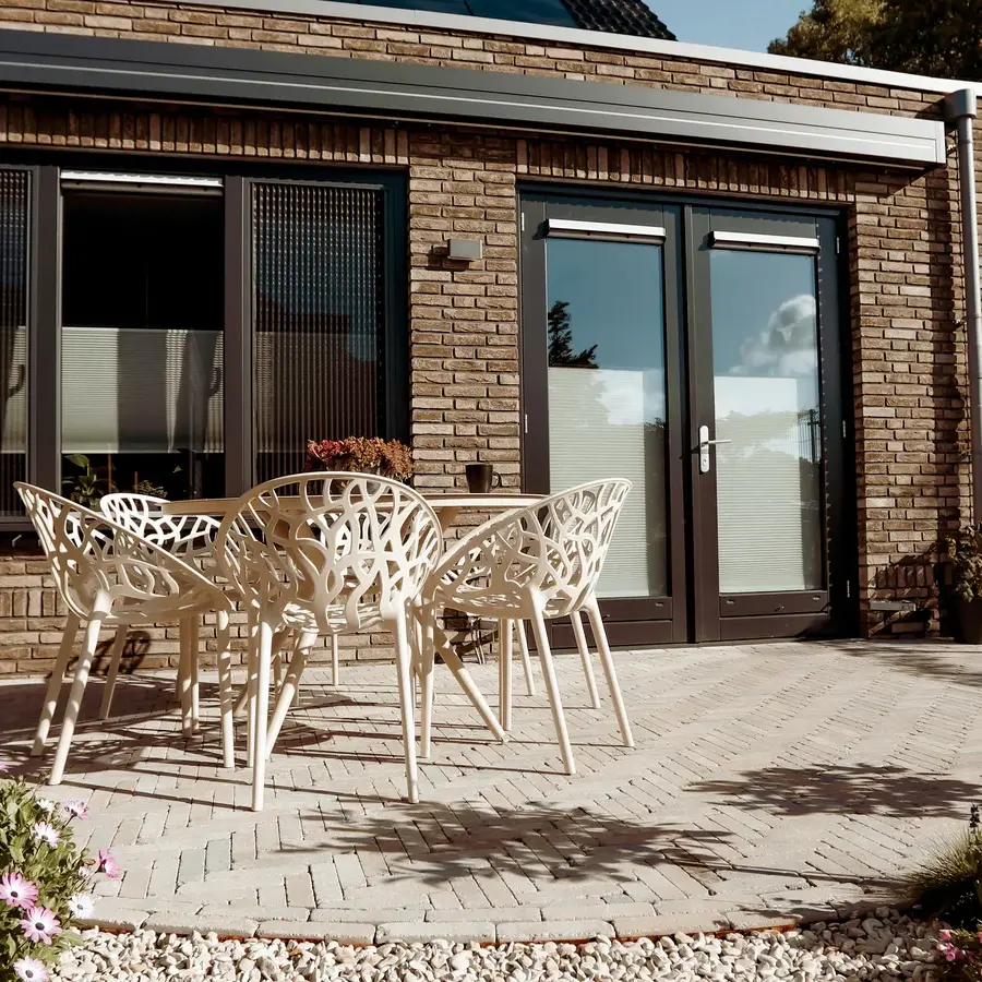 Strakke tuin met sfeervolle houten poortconstructie en buitenkeuken