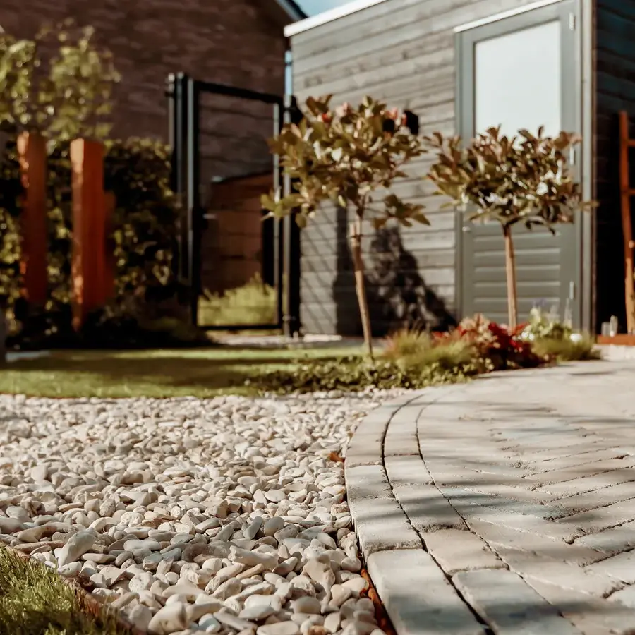 Strakke tuin met sfeervolle houten poortconstructie en buitenkeuken