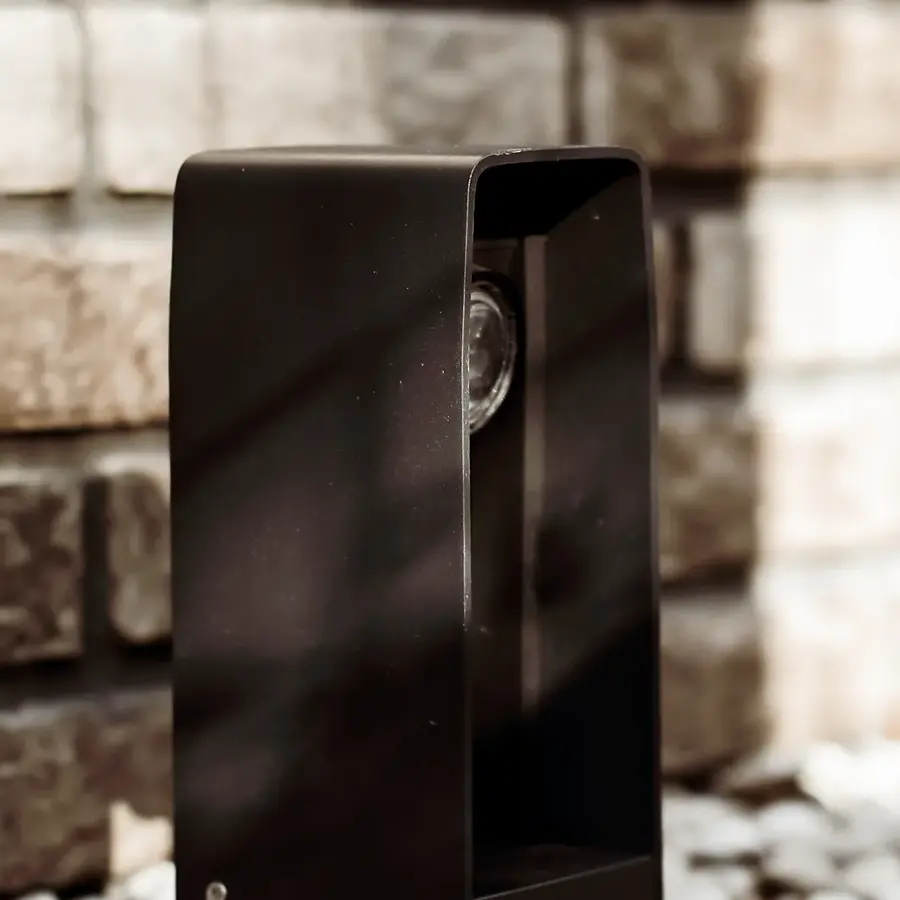 Strakke tuin met sfeervolle houten poortconstructie en buitenkeuken