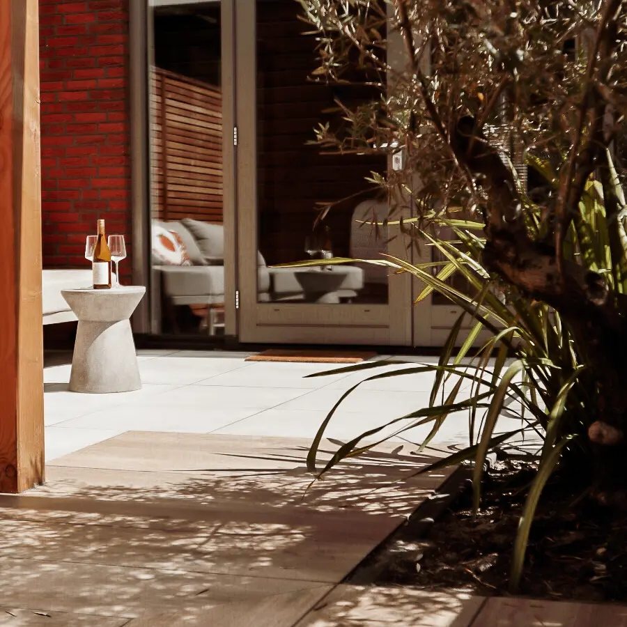 Compacte stadstuin met houten tuinhuis, pergola en mediterrane planten