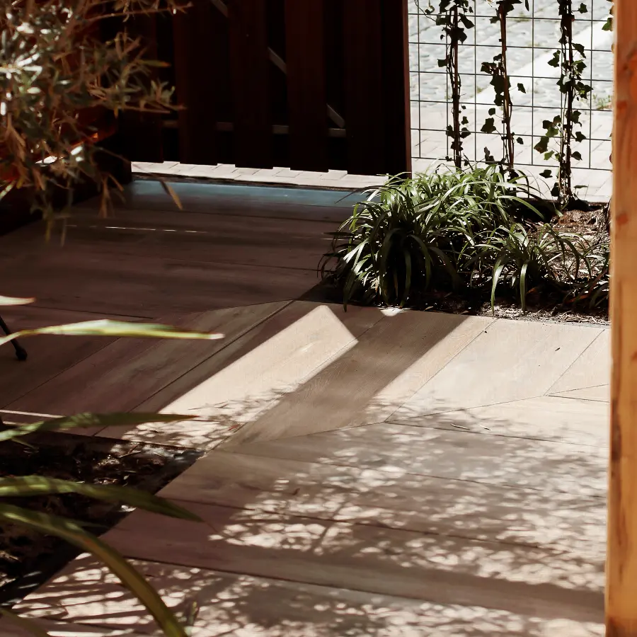 Compacte stadstuin met houten tuinhuis, pergola en mediterrane planten