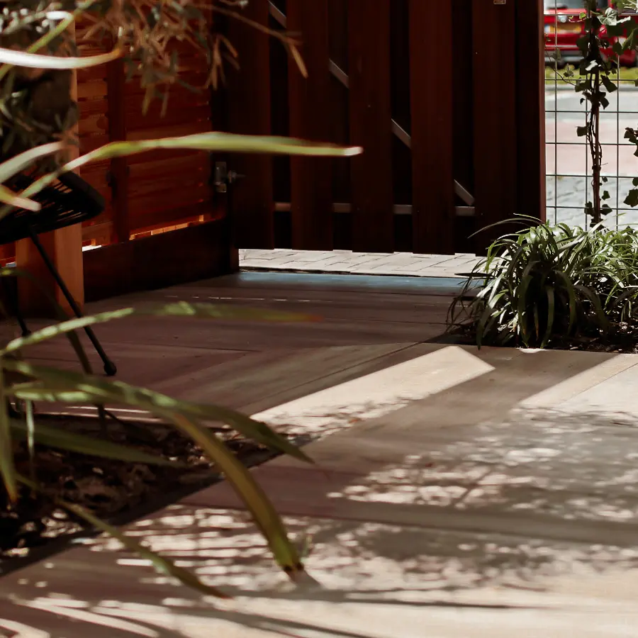 Compacte stadstuin met houten tuinhuis, pergola en mediterrane planten