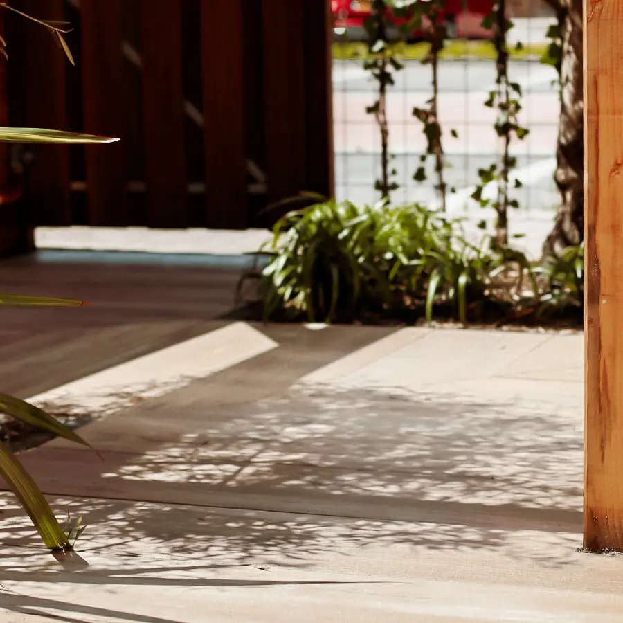 Compacte stadstuin met houten tuinhuis, pergola en mediterrane planten