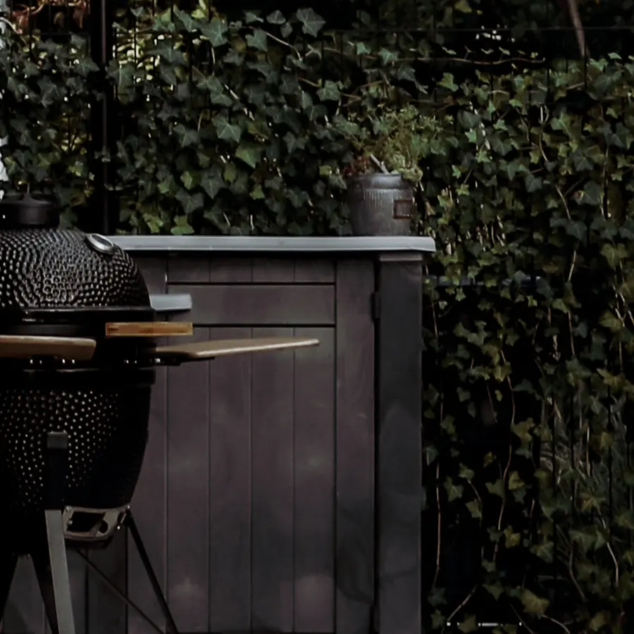 Strakke tuin met sfeervolle houten poortconstructie en buitenkeuken