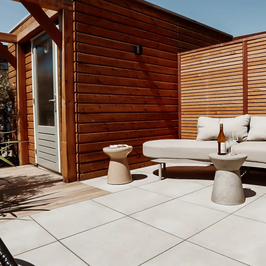 Compacte stadstuin met houten tuinhuis, pergola en mediterrane planten