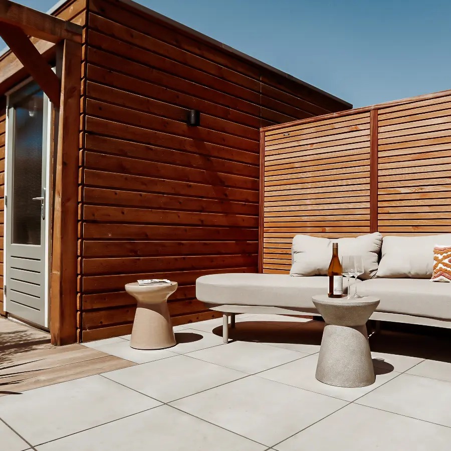 Compacte stadstuin met houten tuinhuis, pergola en mediterrane planten