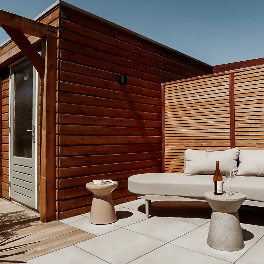 Compacte stadstuin met houten tuinhuis, pergola en mediterrane planten