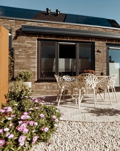 Strakke tuin met sfeervolle houten poortconstructie en buitenkeuken