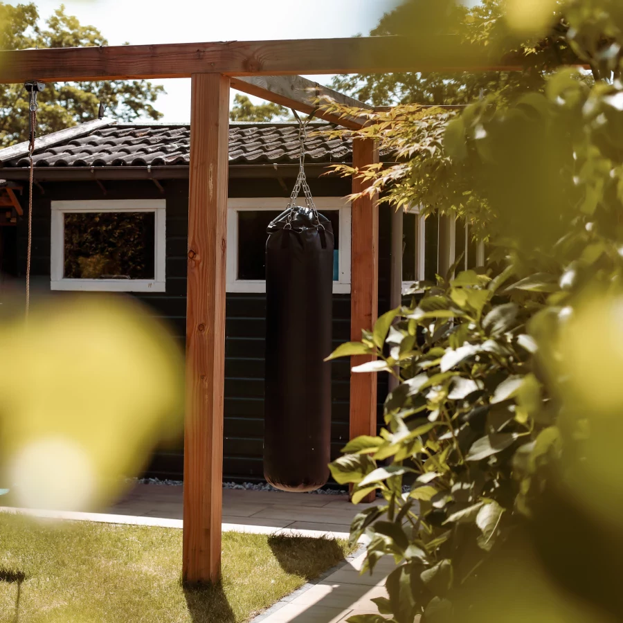 Kindvriendelijk ingerichte tuin met schommel, bokszak en trampoline