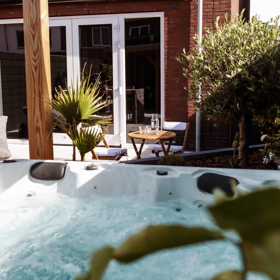 Tuin met jacuzzi, maatwerk bar- en buitenkeuken en overkapping