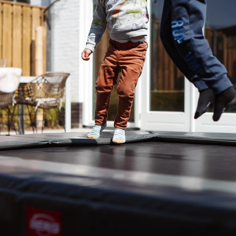 Vierkante tuin met overkapping en ingegraven trampoline