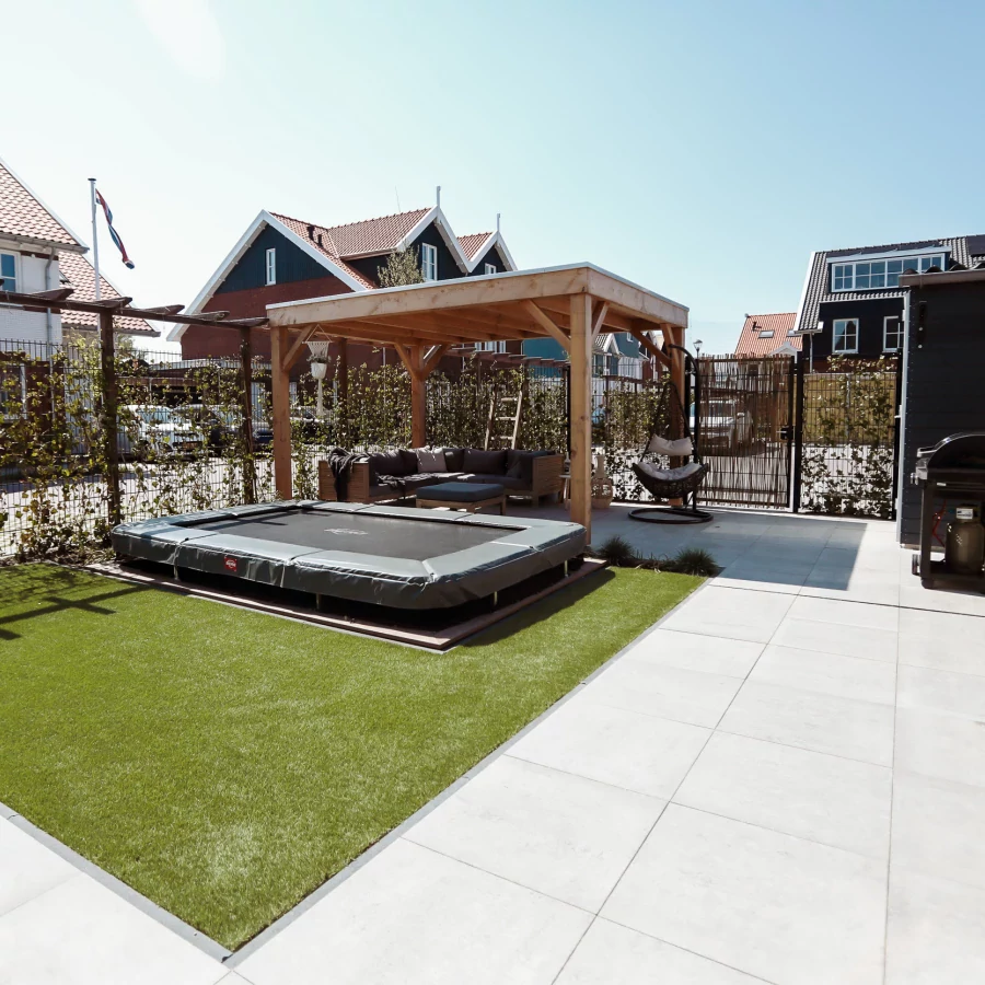 Vierkante tuin met overkapping en ingegraven trampoline