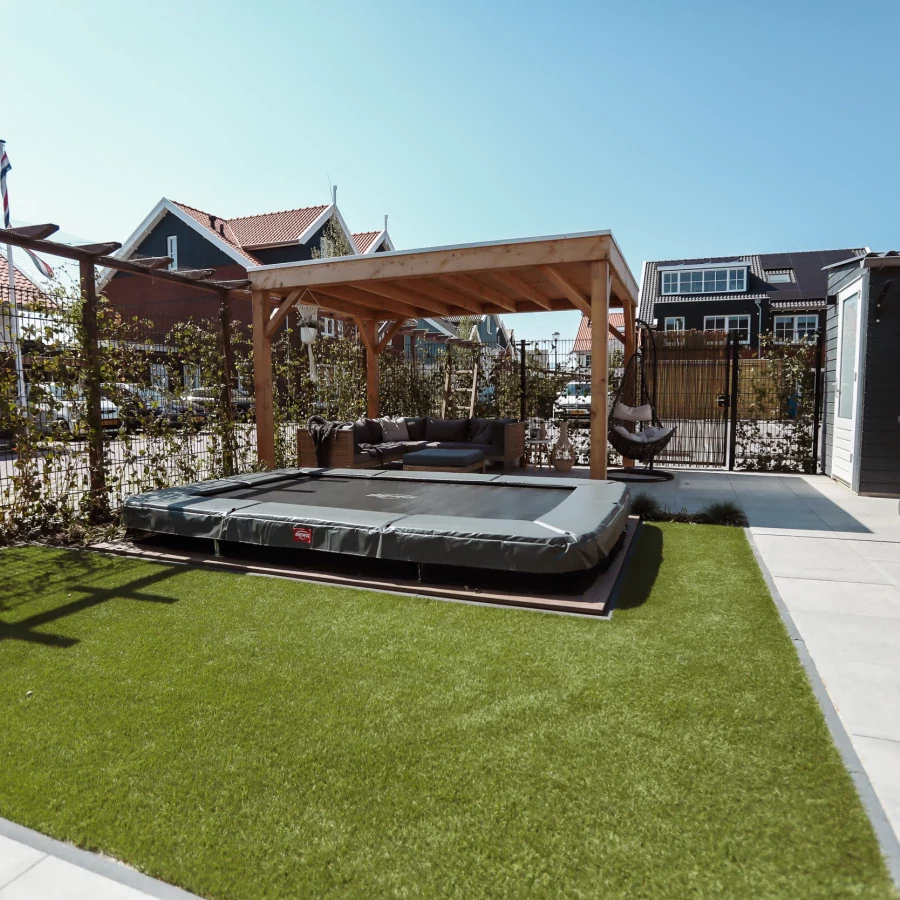 Vierkante tuin met overkapping en ingegraven trampoline