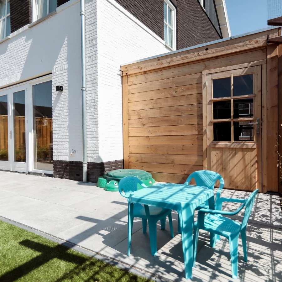 Vierkante tuin met overkapping en ingegraven trampoline