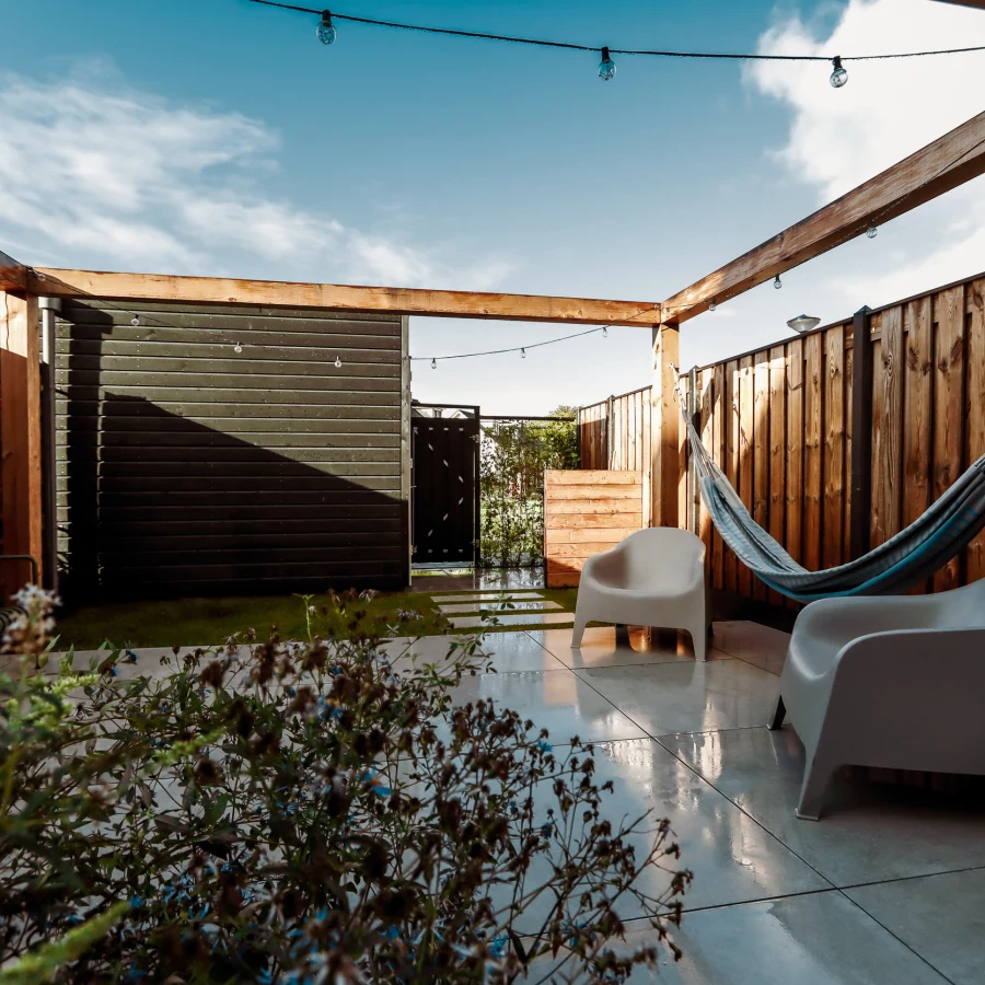 Stadstuin met middenterras, hangmat en grote pergola