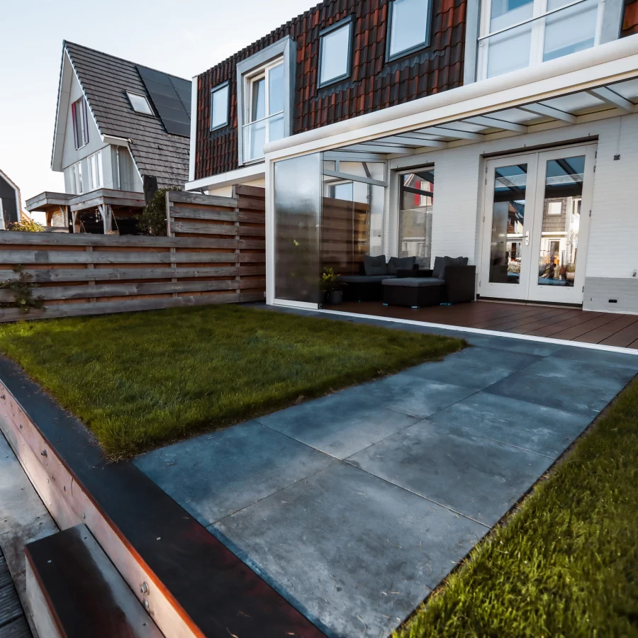 Compacte tuin aan het water met serre en aanlegsteiger