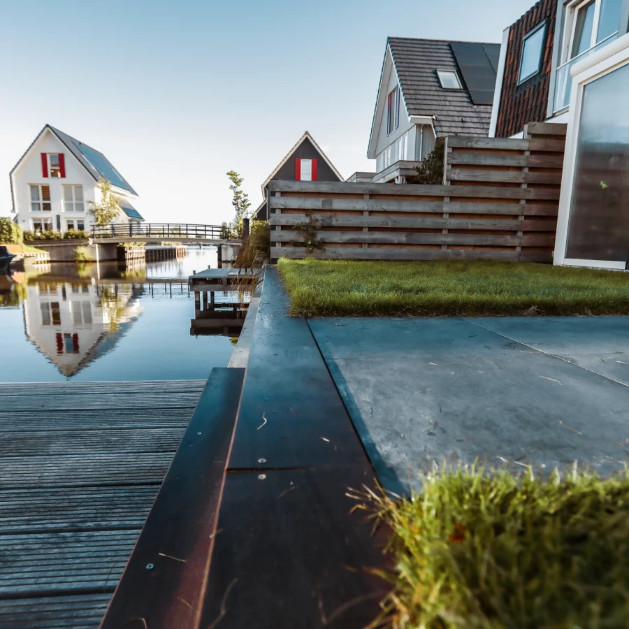 Compacte tuin aan het water met serre en aanlegsteiger