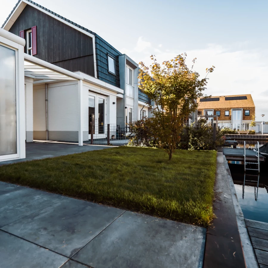 Compacte tuin aan het water met serre en aanlegsteiger