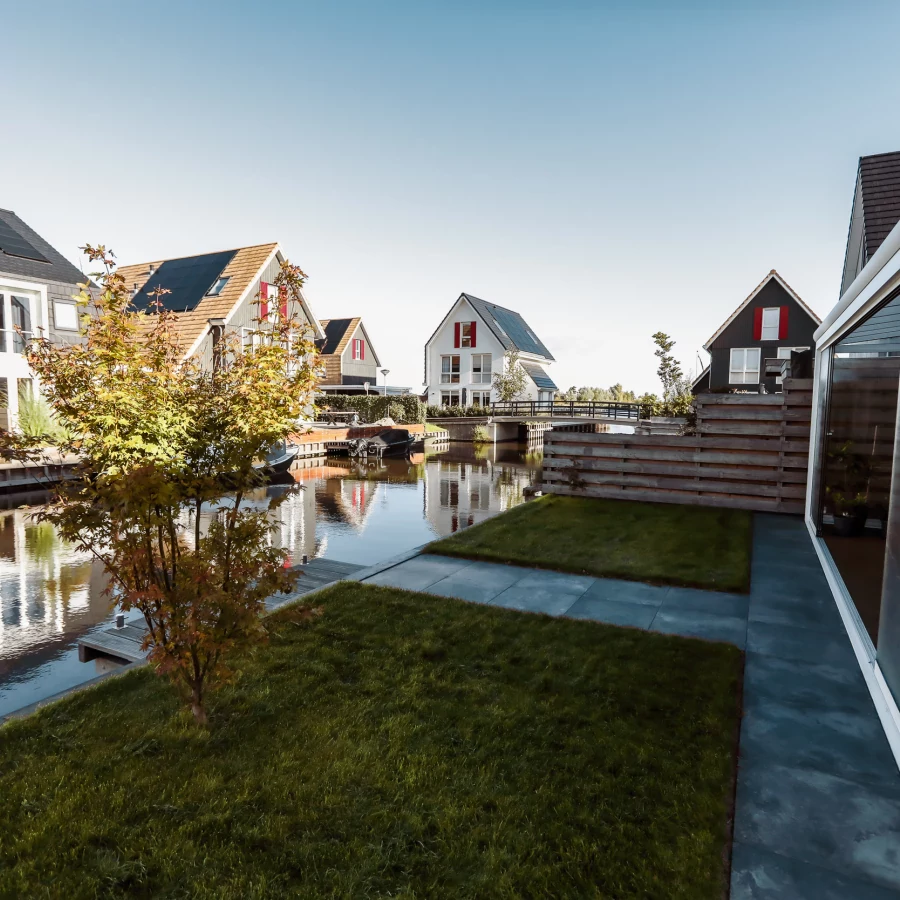 Compacte tuin aan het water met serre en aanlegsteiger