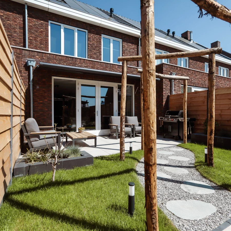 Stadstuin met twee terrassen, lange border en boomstam pergola