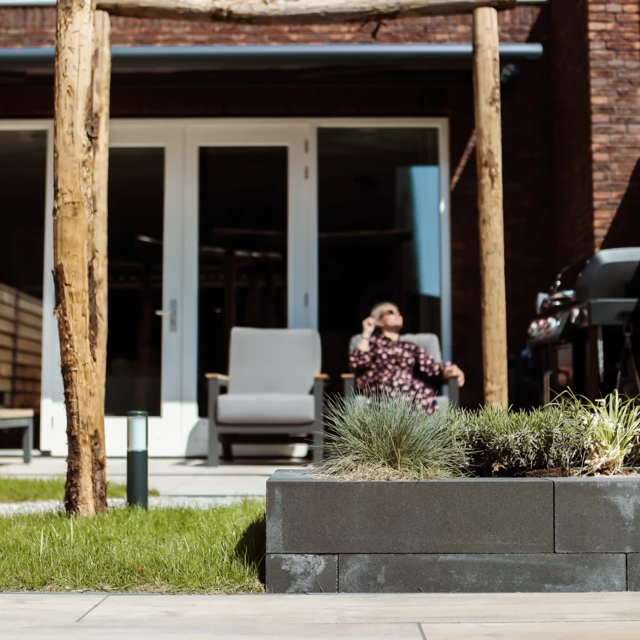 Stadstuin met twee terrassen, lange border en boomstam pergola