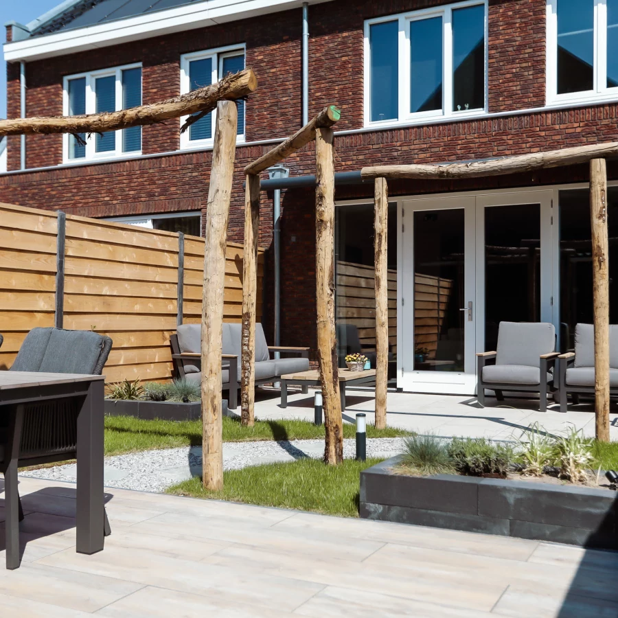 Stadstuin met twee terrassen, lange border en boomstam pergola