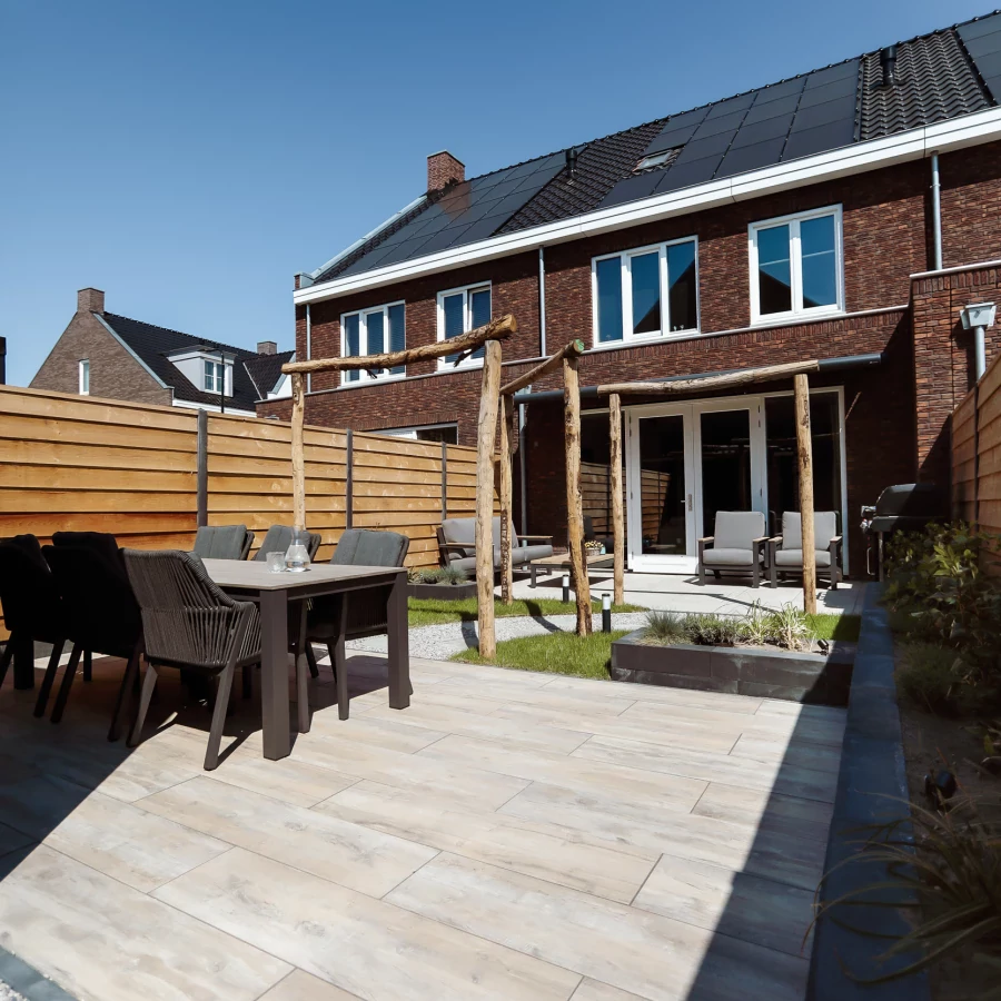 Stadstuin met twee terrassen, lange border en boomstam pergola