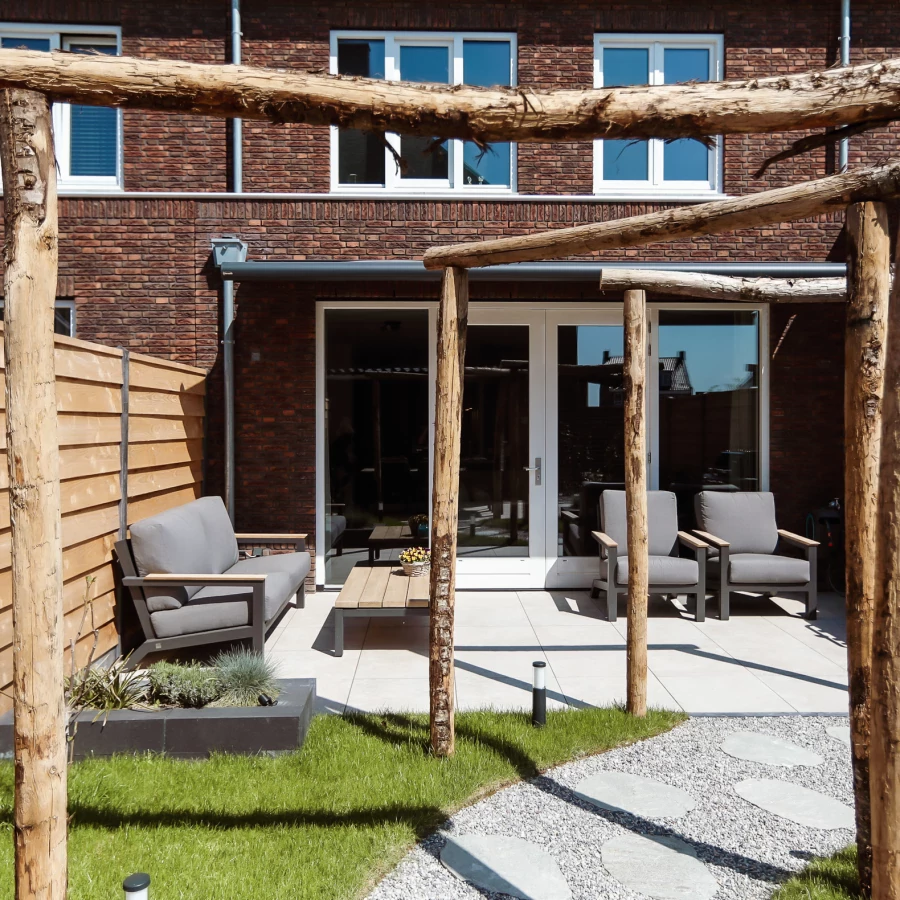 Stadstuin met twee terrassen, lange border en boomstam pergola