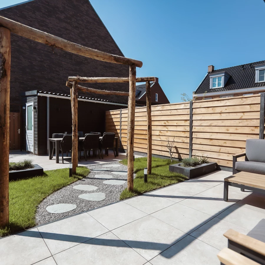 Stadstuin met twee terrassen, lange border en boomstam pergola