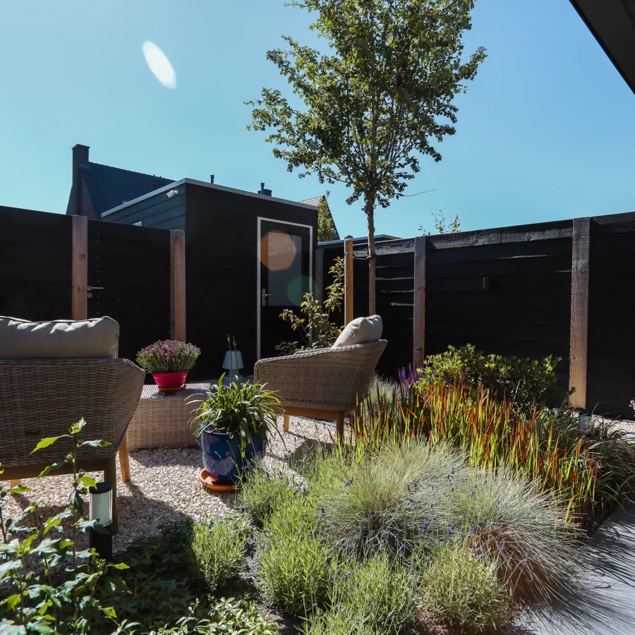 Stadstuin met veel groen rondom de jacuzzi onder een pergola