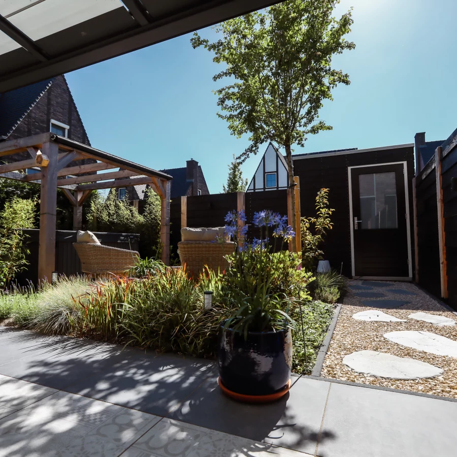 Stadstuin met veel groen rondom de jacuzzi onder een pergola