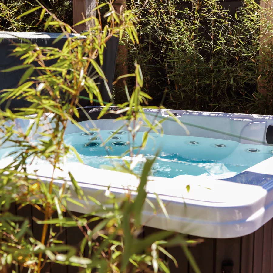 Stadstuin met veel groen rondom de jacuzzi onder een pergola