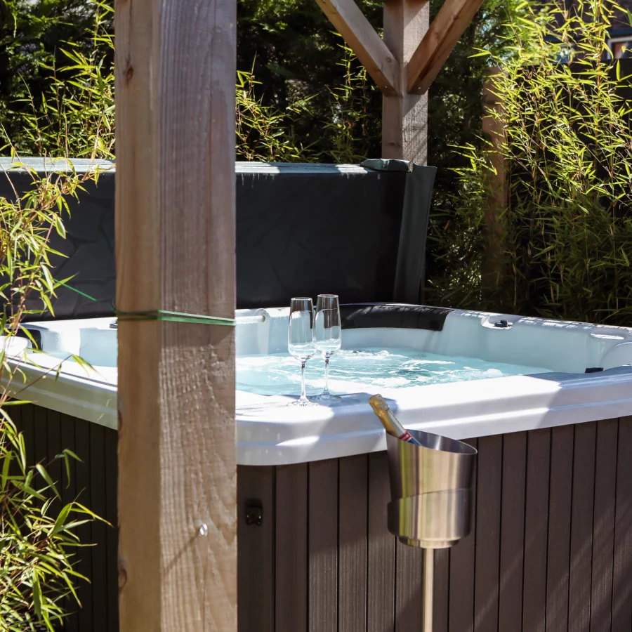 Stadstuin met veel groen rondom de jacuzzi onder een pergola