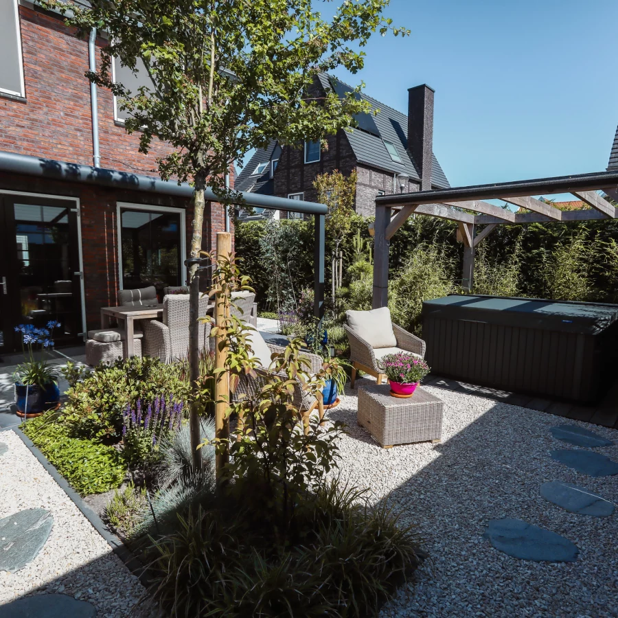 Stadstuin met veel groen rondom de jacuzzi onder een pergola