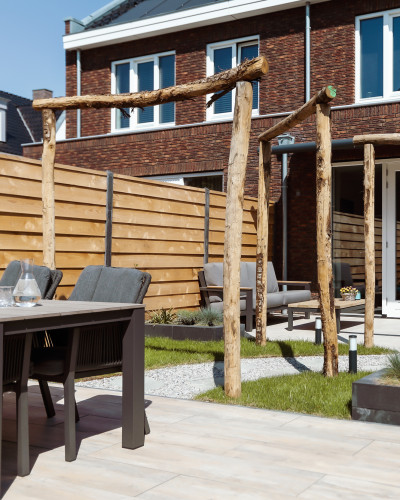 Stadstuin met twee terrassen, lange border en boomstam pergola